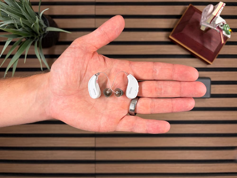 Fortell AI prescription hearing aids held in a hand